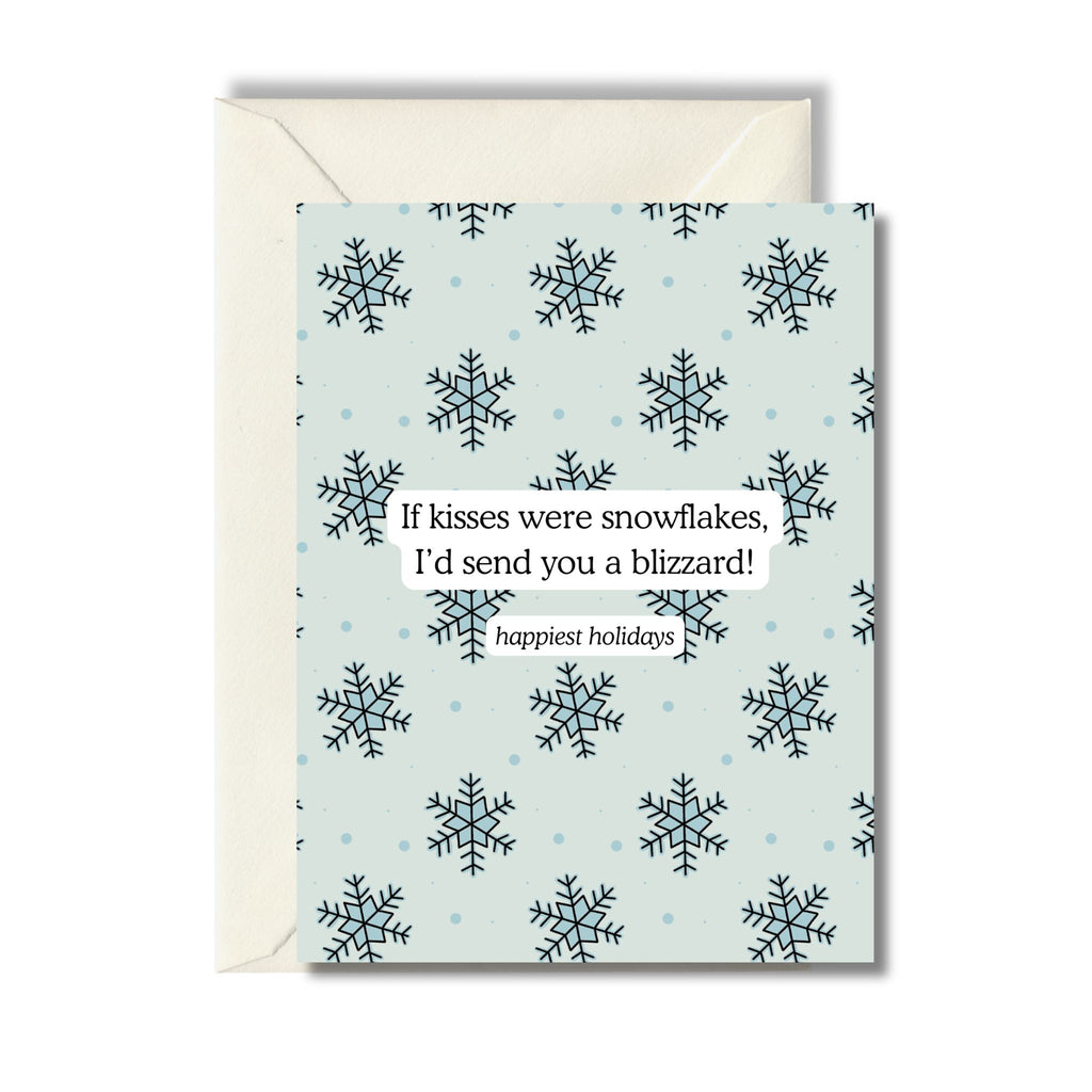 A holiday greeting card with blue snowflake designs and an inspirational message that reads: "If kisses were snowflakes, I'd send you a blizzard! Happiest holidays"