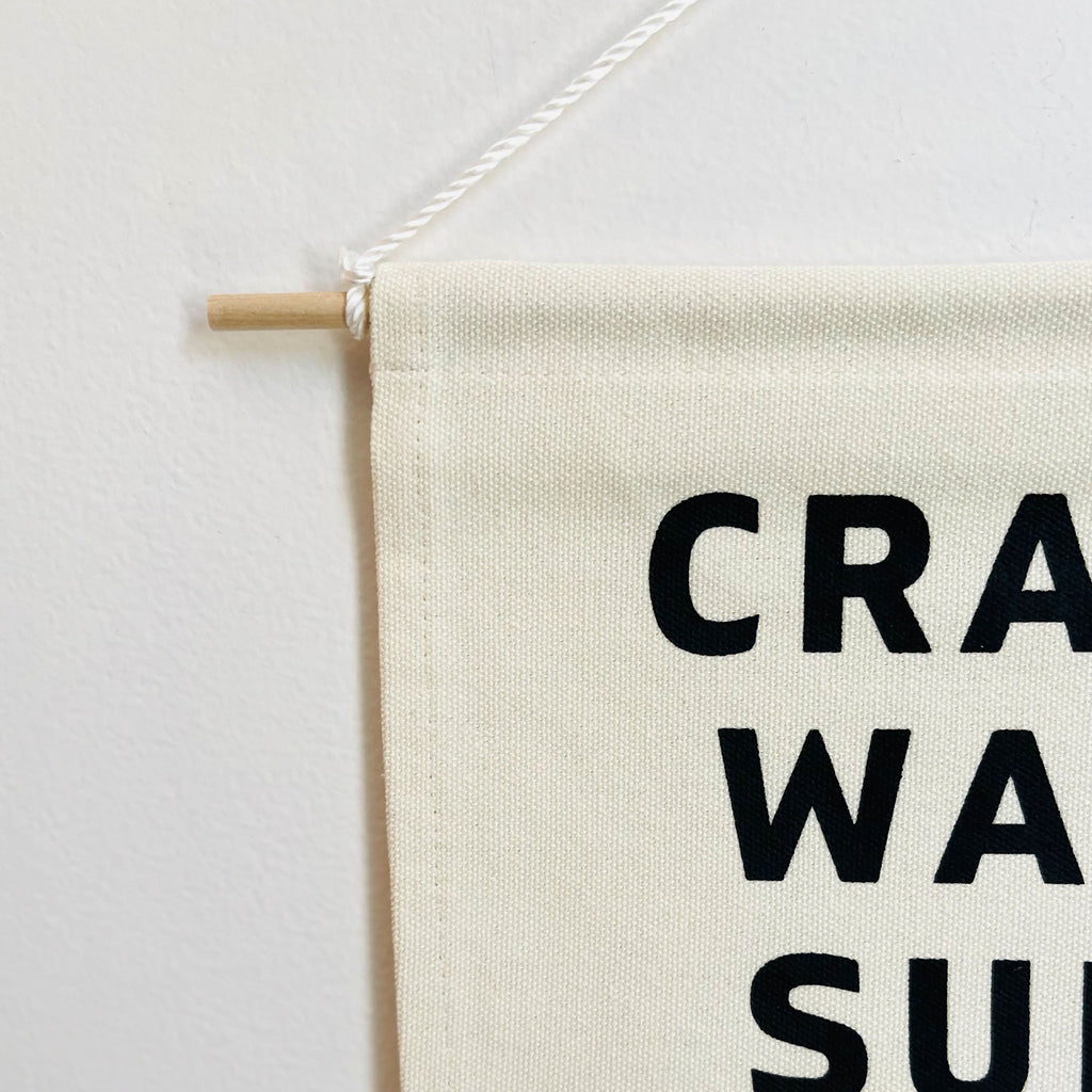 small canvas banner with words crawl walk surf and ocean waves outline. natural canvas with black lettering