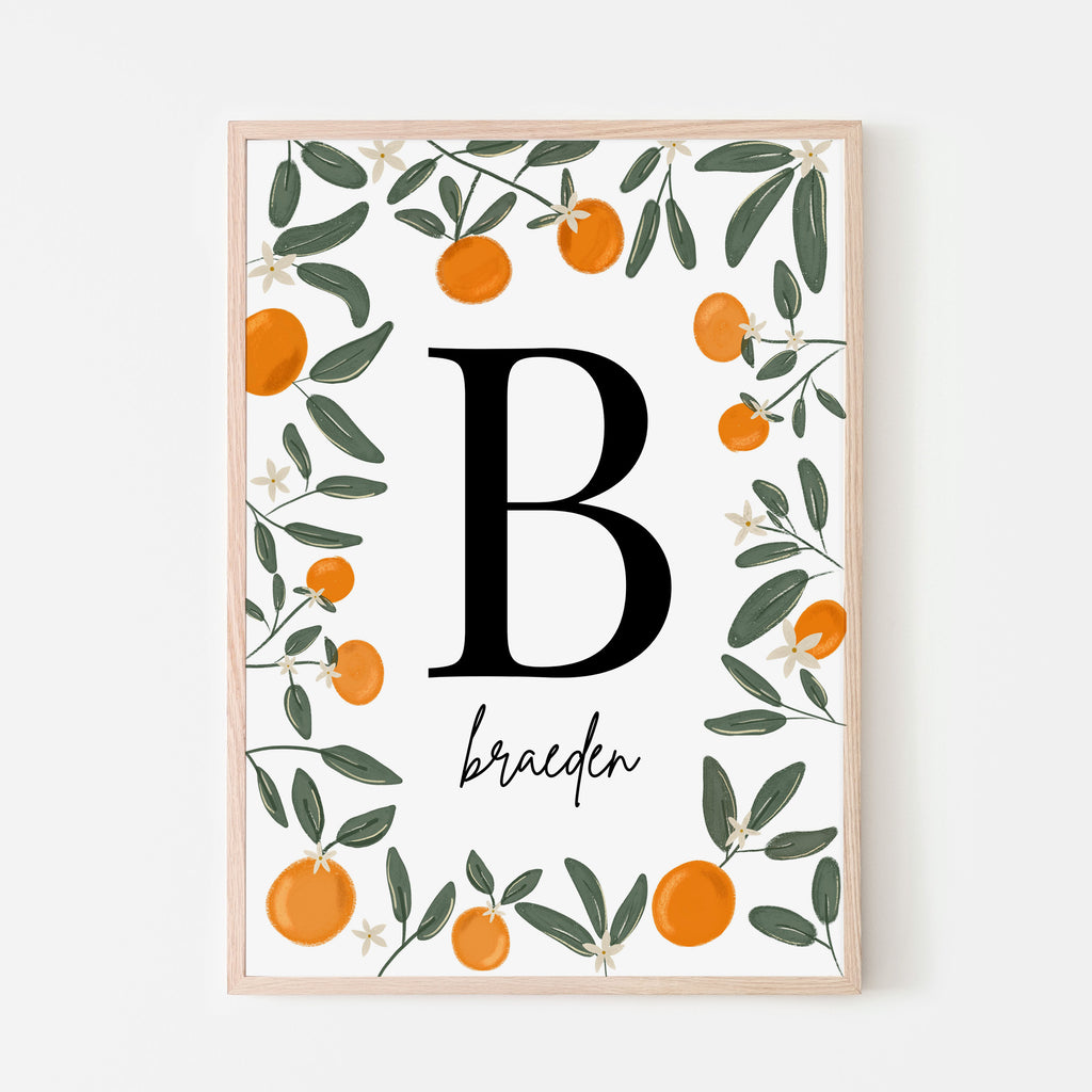 Little cutie name sign with a bold black letter and cursive first name with surrounding clementine oranges, leaves and orange blooms with a white background. 