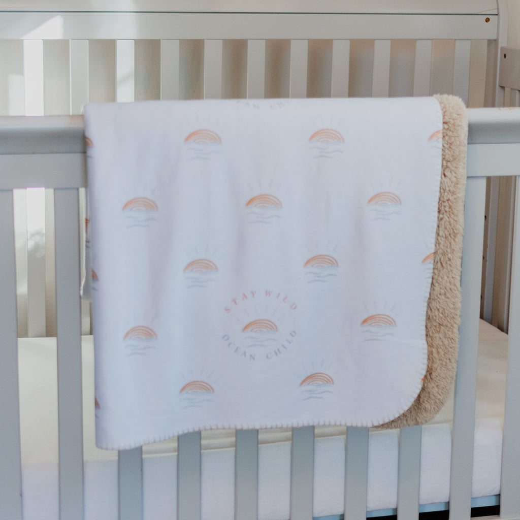 Stay Wild Ocean Child Sherpa Infant Baby Blanket with tan fleece in baby crib nursery room